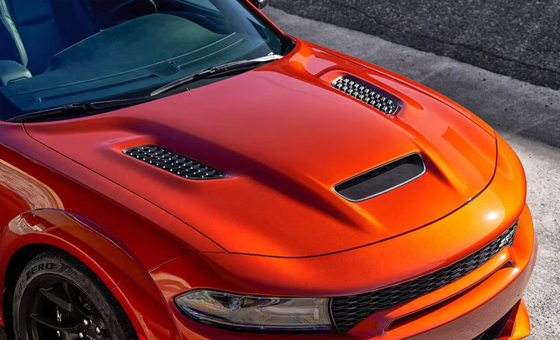A raised angle of the hood on an orange 2023 Dodge Charger SRT Hellcat.